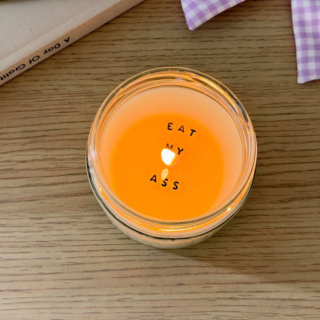 Bougie allumée sur une table, qui dévoile un message caché